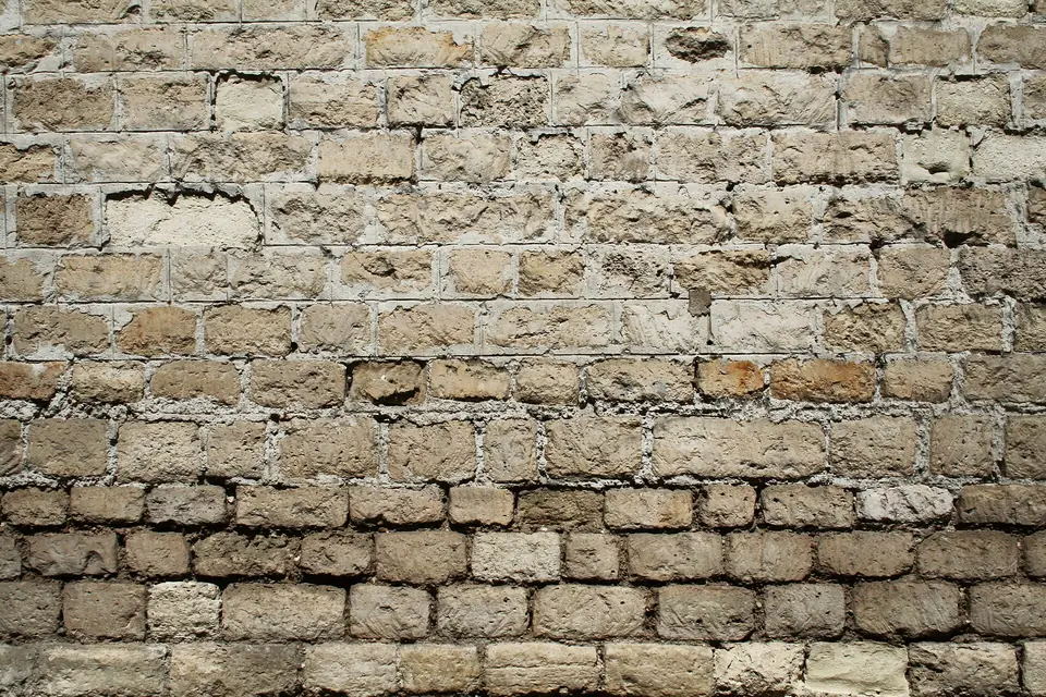 Mur mitoyen en moellons de calcaire smillés, partiellement jointoyés au mortier de chaux avec des joints tirés au fer.